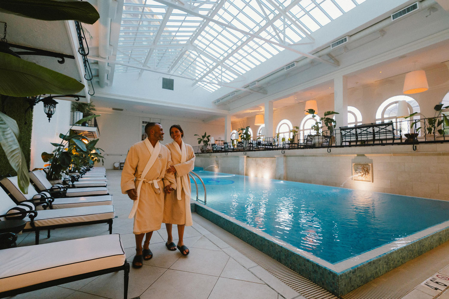 A couple walking alongside the indoor pool at The Historic Cavalier Hotel