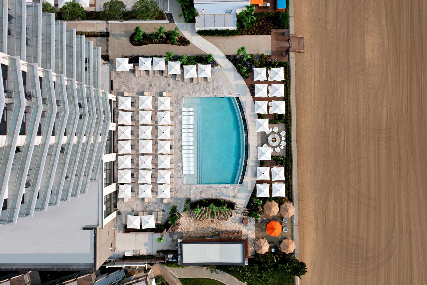 An aerial birds eye view of a resort pool next to a beach
