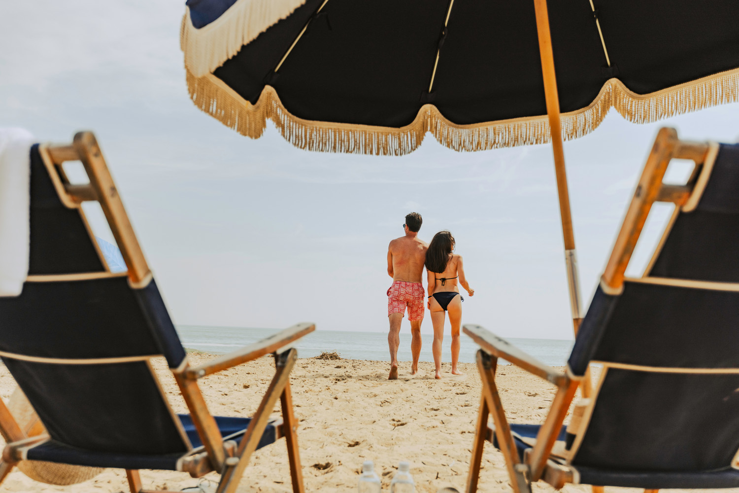 A couple enjoying beach chairs and umbrellas at the Cavalier Resort Virginia Beach